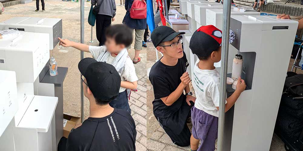 ウォータースタンドからマイボトルに給水する子供