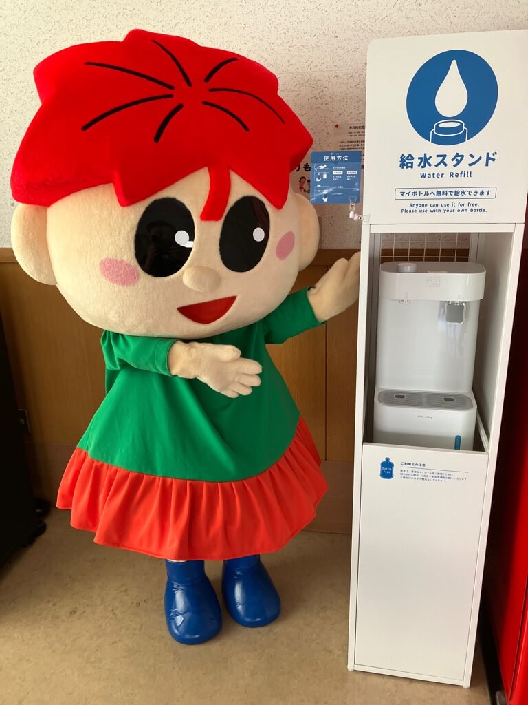 箕輪町イメージキャラクター「もみじちゃん」とマイボトル用給水機「ウォータースタンド」class=